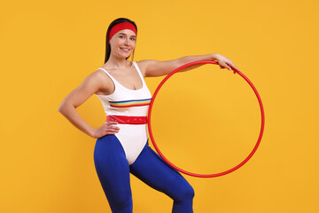 Wall Mural - Smiling woman with hula hoop on orange background