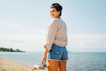 Young caucasian woman is going to the beach with straw bag	