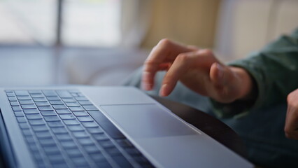 Wall Mural - Man hands using laptop touchpad in cabinet. Closeup unknown person working alone