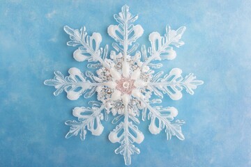 Wall Mural - Decorative snowflake with silver and pink accents on blue background