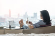 © Chinnapong - Work-Life balance, life quality, work and travel concept with Asianbusiness woman relaxing, take it easy resting in modern city hotel guest room or luxury home living room with computer and smartphone