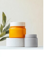 Poster - Minimalist Beauty Setup Vibrant Orange and Gray Cosmetic Jars on Stone Plinth with Foliage - Modern Skincare Aesthetic for Eco-Conscious Branding and Wellness Promotion