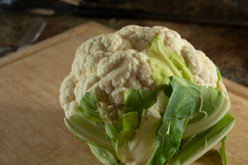 Wall Mural - A view of a cauliflower on a wooden cutting board.