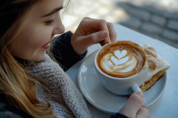 Wall Mural - A young girl holding a cup of coffee in her hands, enjoying the moment