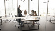 © fizkes - Businesspeople negotiate in office, gathered around conference table, engaged in formal discussion or presentation. Boss lead briefing event, share corporate strategy, solve business issues together