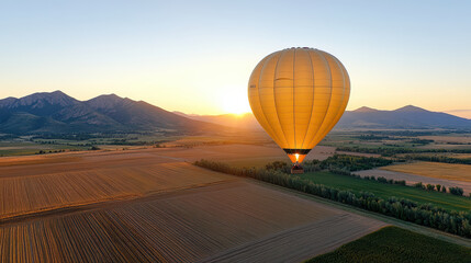 Wall Mural - hot air balloon floats over golden valley at sunset, creating serene view