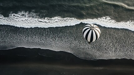 Canvas Print - Hot air balloon flight over dark sand beach, ocean waves. Travel, adventure