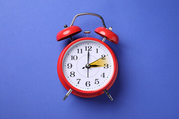 Poster - Daylight saving time. Red alarm clock on blue background, top view. Highlighted area showing time change by one hour forward