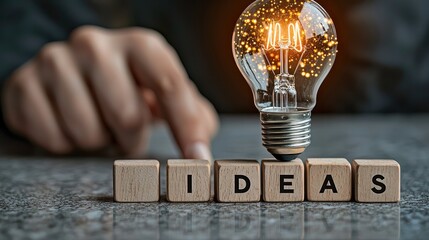 Poster - A hand holding a lightbulb that radiates a warm yellow-orange glow, placed on four wooden blocks labeled 