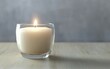 ©  Yassine DS - Luxury aromatherapy candle in a transparent glass jar with a soft burning flame on a wooden table creating a warm cozy and serene atmosphere for home decor and relaxation photography