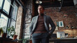 © HavingFunShop - Young startup founder in a casual blazer and turtleneck, standing in a creative loft-style workspace with exposed brick walls,
