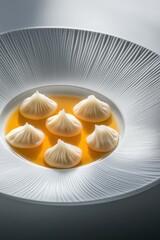 Wall Mural - Delicate soup served in a white plate with elegant arrangement of dumplings in a modern dining setting