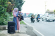 © Fajar - asian muslim women with suitcase prepare to go. concept of man and woman travelling for eid mubarak celebration