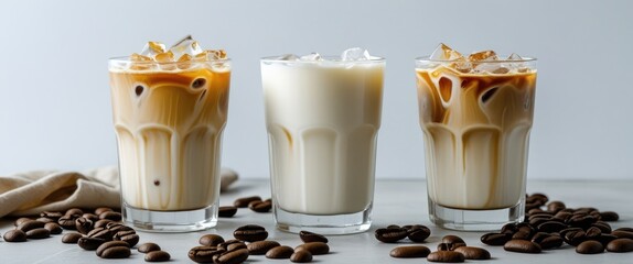 Poster - Iced Coffee Beverages with Milk and Ice in Glasses Surrounded by Coffee Beans on White Background