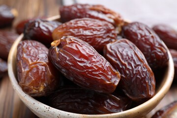 Wall Mural - Many tasty dried dates in bowl on table, closeup