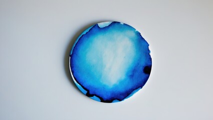 Fototapete - Blue watercolor circular splash with various shades on a clean white background creating a serene artistic effect.