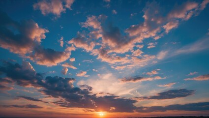 Wall Mural - vibrant sunset over blue cloudy sky with soft clouds and warm evening light