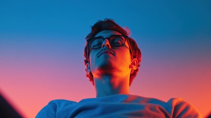 Poster - Man with glasses looking up, illuminated by colored lights