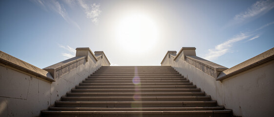 Stairway leading to bright sunlight with a clear blue sky, symbolizing aspiration and enlightenment