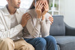 © KMPZZZ - Anxiety depress, grief asian young couple comfort discuss concern encourage empathy and support, worry about problem mental health about relationship after marriage, upset wowan sad on sofa at home.