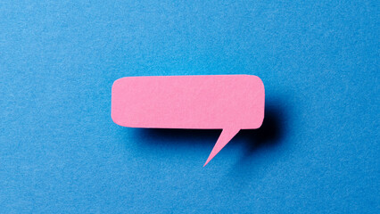 Aufkleber - Pink blank cut out paper speech bubble with shadow and copy space for text on blue background, close-up flat lay top view conceptual backdrop