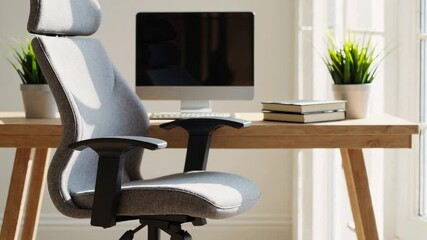 Aufkleber - Sunlight illuminates a modern home office featuring an ergonomic chair, a desktop computer, books, and a potted plant, creating a serene and productive workspace
