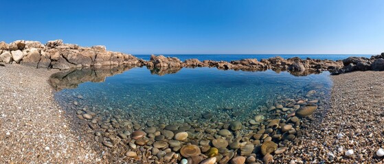 Wall Mural - A large body of water is reflected in the rocks