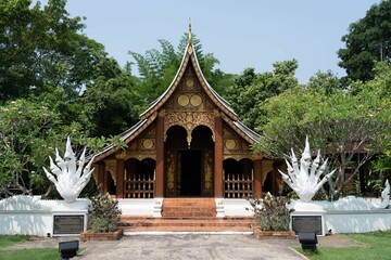 Wall Mural - Traditional Thai temple with lush greenery.