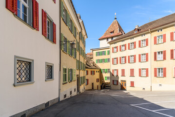 Traditional apartment buildings with colourful shutters border a square in Chur old city centre on a clear spring day. Canton of Grison, Switzerland.