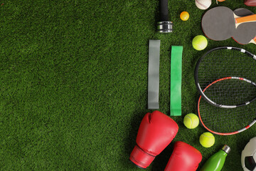 Wall Mural - Different sport equipment on artificial grass, flat lay. Space for text