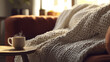 © ABX - A cozy blanket draped over a couch, a cup of tea, rest