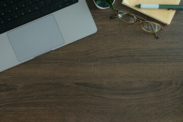 Wall Mural - Overhead view of a workspace corner showcasing a laptop and accessories, perfect for productivity themes.