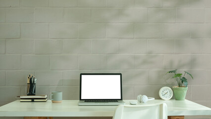 Fototapete - Home workspace with a laptop featuring a blank screen, books, a coffee mug.