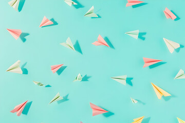 Poster - Colorful paper airplanes flying in the same direction on a turquoise background