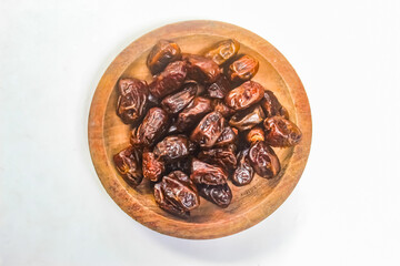 Wall Mural - dates in a wooden bowl on a white background