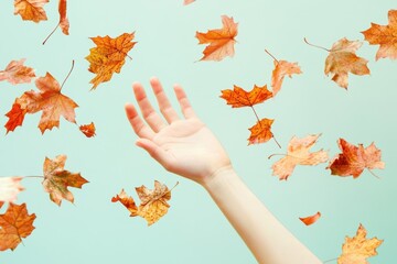 Canvas Print - Hand reaches upward as autumn leaves fall on light background