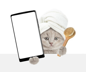 Leinwandbilder - Cute tiny kitten with towel on it head holds  big smartphone with white blank screen in it paw above blank white banner. isolated on white background