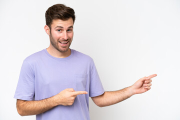 Wall Mural - Young caucasian man isolated on white background surprised and pointing side