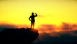 © Who is Danny - Silhouette of a person standing on a cliff edge looking into the distance at sunset.