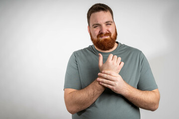 Man touching wrist of hand feeling pain on gray background. Tunnel syndrome, neuralgia, pinched nerve in arm after injury, consequences of computer work. Health problems, discomfort, symptom concept.