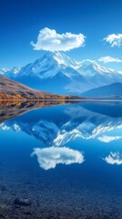 Wall Mural - Snow capped mountains reflecting in a lake under a blue sky