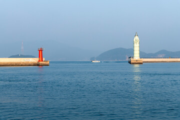 Wall Mural - lighthouse and sailboat on the sea