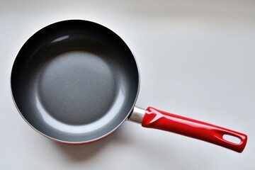 Poster - A close-up of a frying pan with a bright red handle on a white background