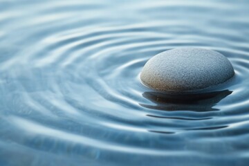 Wall Mural - a solitary rock sits in the center of a calm body of water, surrounded by gentle ripples