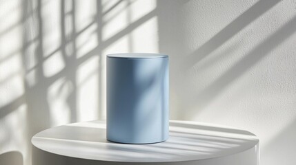 Poster - A pastel blue cylinder podium stands elegantly in a serene space, casting delicate shadows on a light surface, showcasing a harmonious blend of color and light