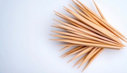 Poster - a high angle, close up shot depicts numerous light brown, pointed wooden toothpicks arranged in a ra