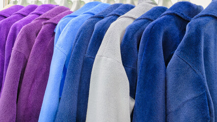 Poster - A row of clothes hanging on a clothesline, with a variety of colors including blue, purple, and gray