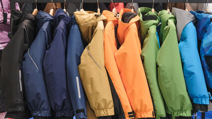 Poster - A rack of colorful jackets hanging on a rack. The jackets are of different colors and styles. Scene is cheerful and lively, as the variety of colors and styles creates a sense of diversity