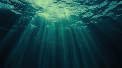 Wall Mural - Sunbeams penetrate deep ocean water creating ethereal scene