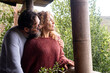 © simona - A happy adult couple enjoys a quiet moment together on the balcony, surrounded by nature, embracing each other while dreaming of a bright future together, experiencing a peaceful vacation in chalet